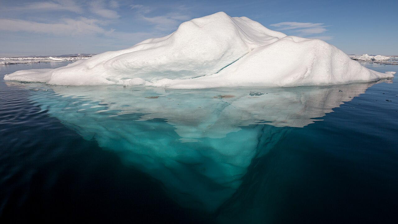 Iceberg en el Ártico con su parte sumergida visible bajo el agua transparente